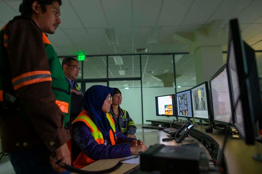 Karyawan sedang memantau operasional kereta tambang melalui monitor